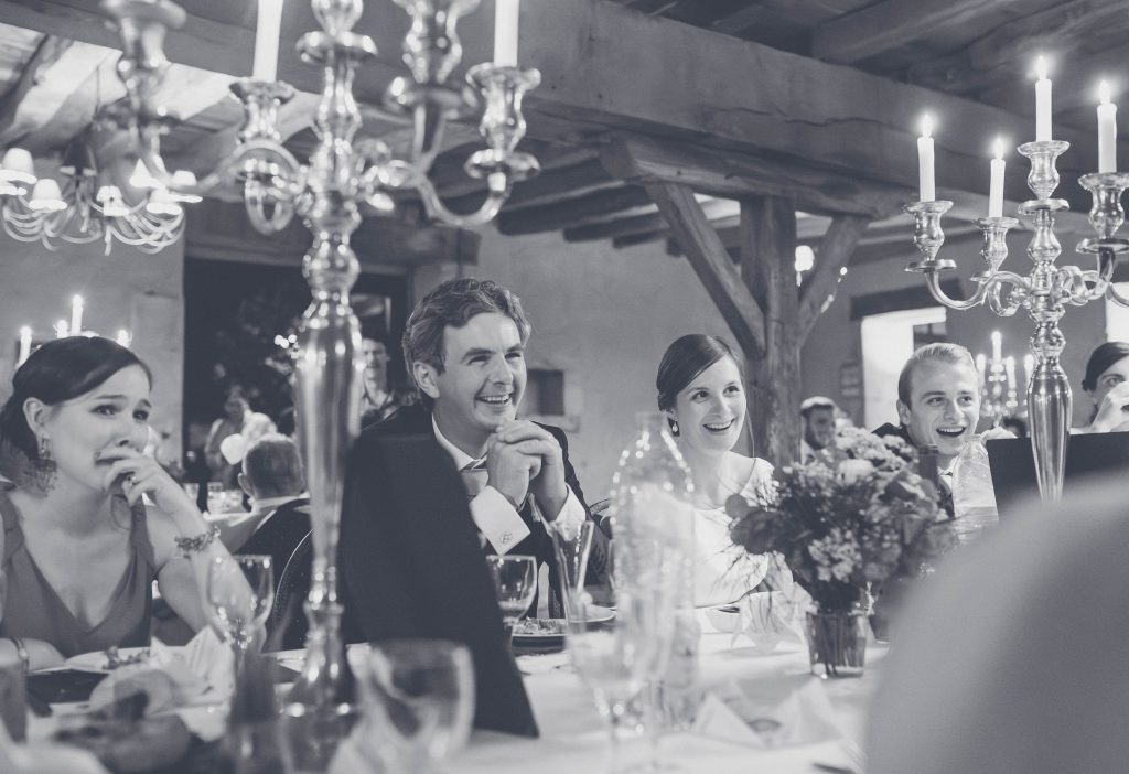 Dîner de mariage aux chandeliers, invités attablés, en noir et blanc