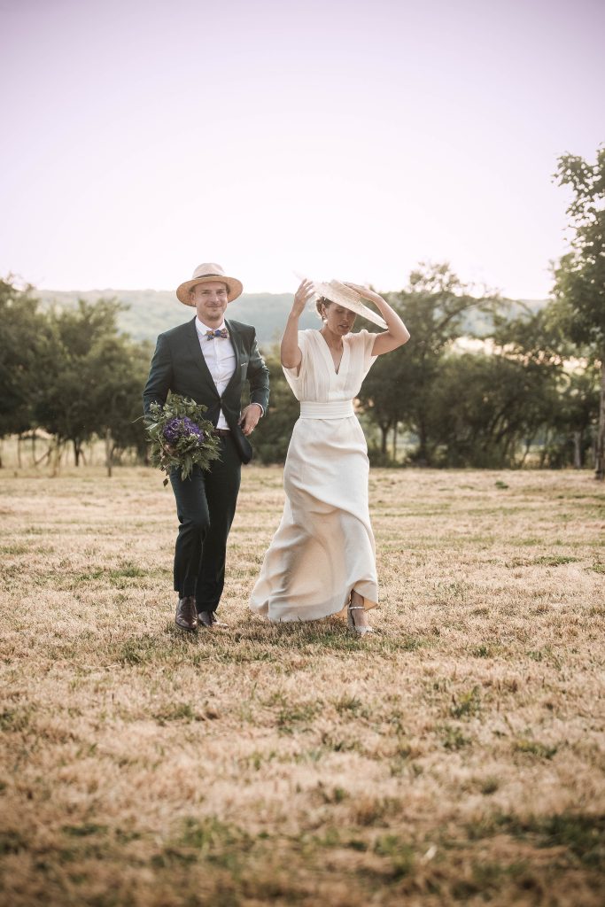 Les mariés dansant dans un pré, le marié au chapeau