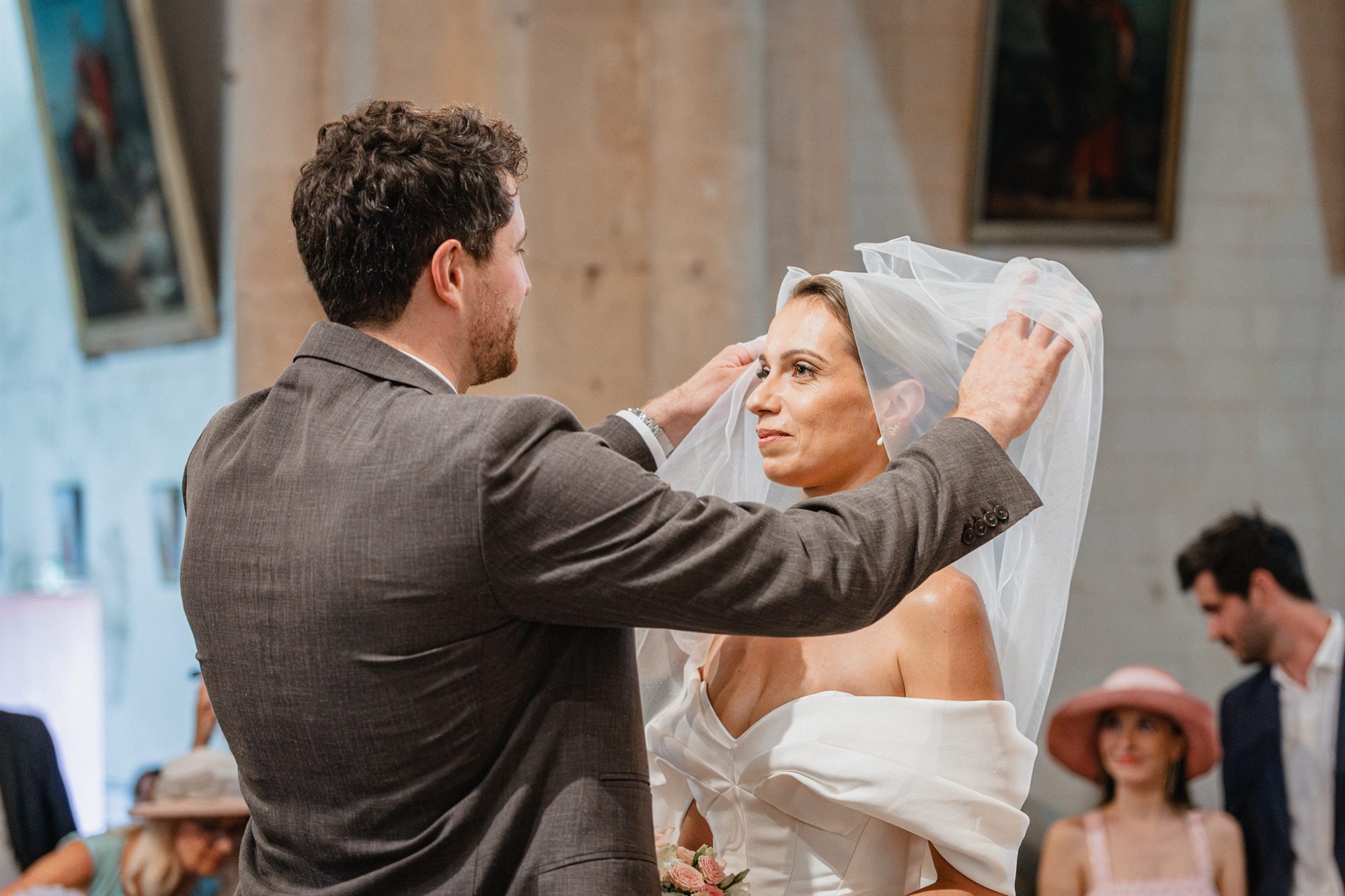 The groom lifts the bride's veil during the ceremony