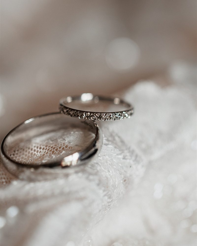 Alliances de mariage posées sur la dentelle de la robe