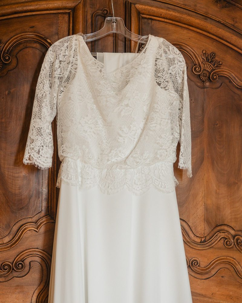 Robe de mariée en dentelle suspendue à une armoire ancienne, O’scarlett