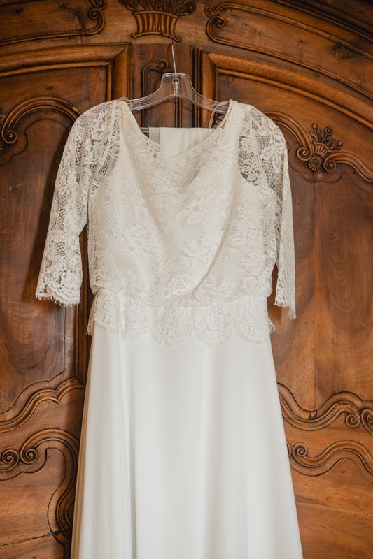 Robe de mariée en dentelle sur une armoire ancienne