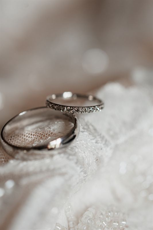 Alliances posées sur la dentelle de la robe
