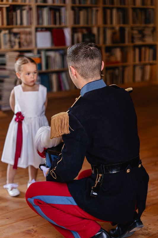 Le marié agenouillé devant une enfant d’honneur