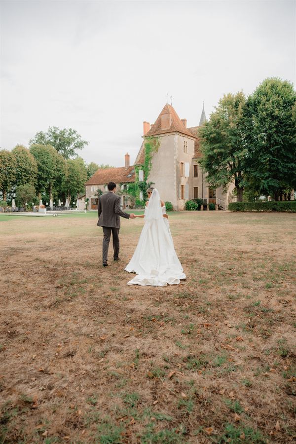 Les mariés au loin, devant la façade du château